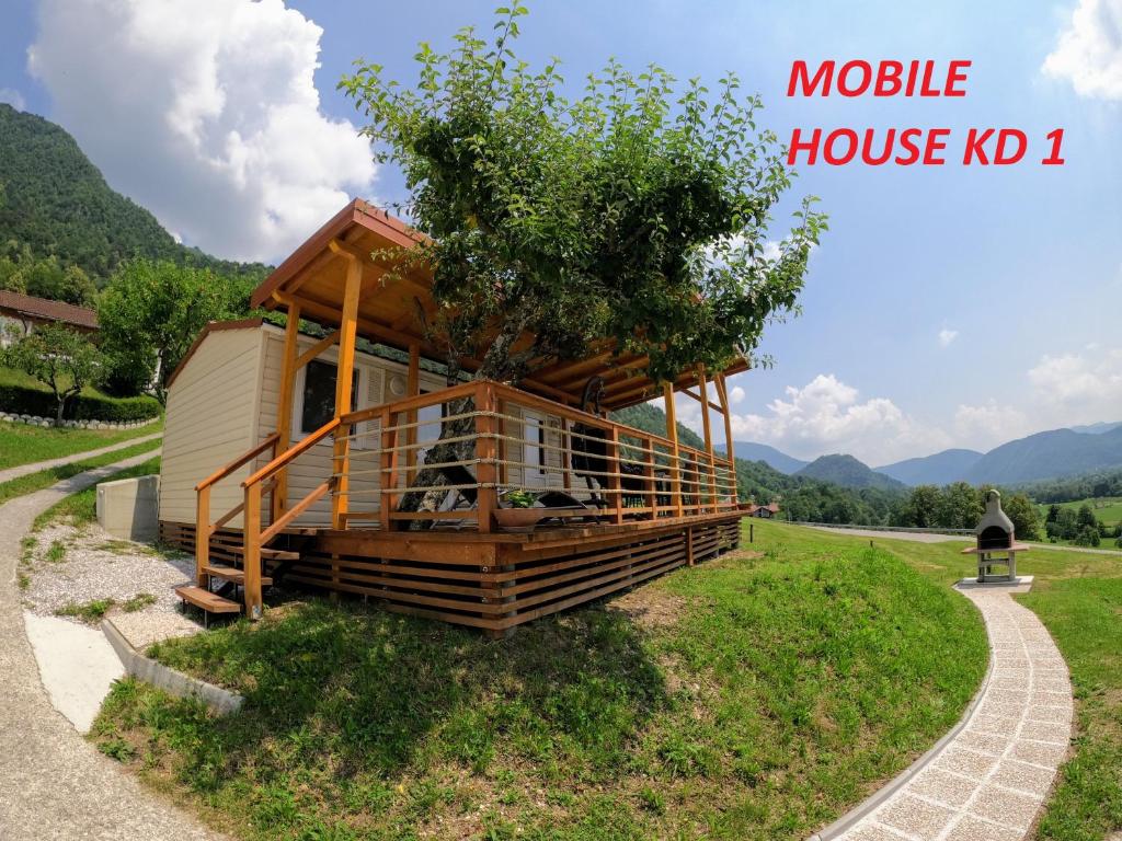 una casa móvil kd con un árbol en el medio en MOBILE HOUSE KD en Tolmin