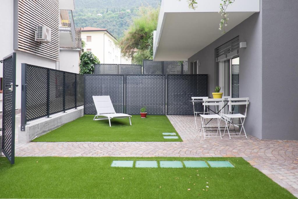 patio z krzesłami, stołem i trawą w obiekcie Terrazze dei Tigli w mieście Riva del Garda