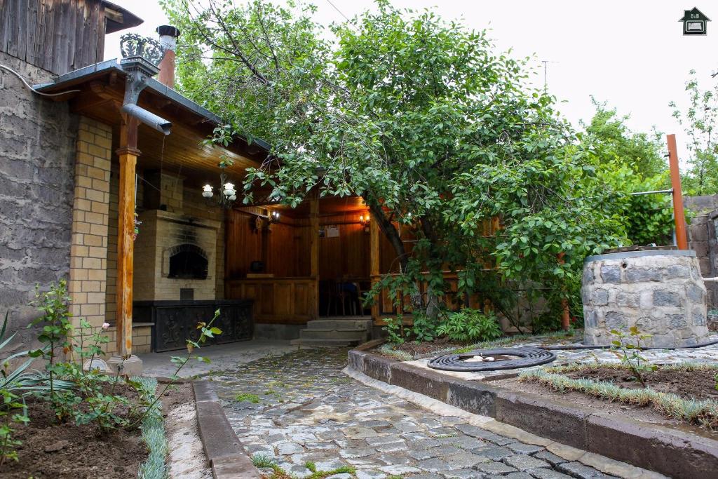 a home with a patio with a tree and a house at Guest House in Gyumri in Gyumri