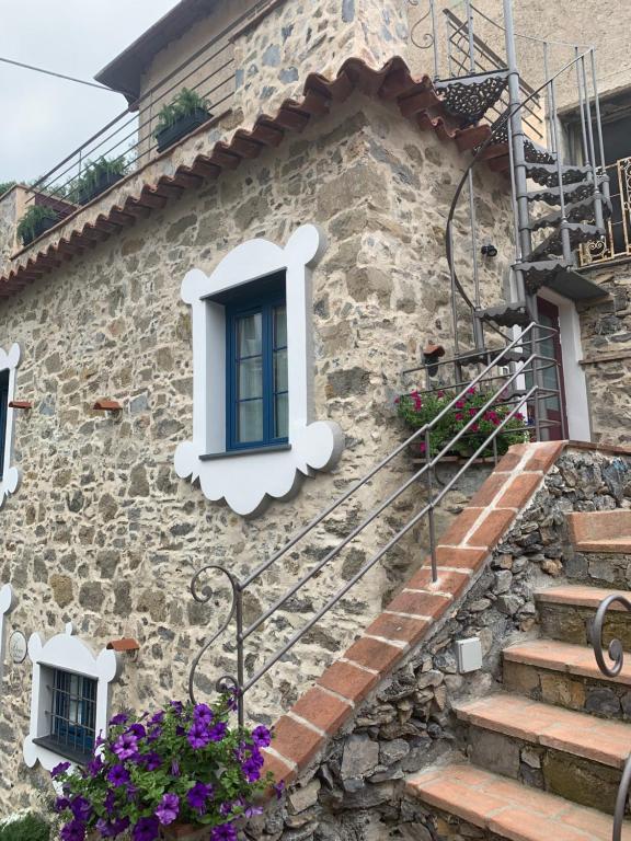 een stenen huis met een blauw raam en een trap bij Le Ciappe Castelbianco Cielo CITR 9020-BEB-0003 in Castelbianco