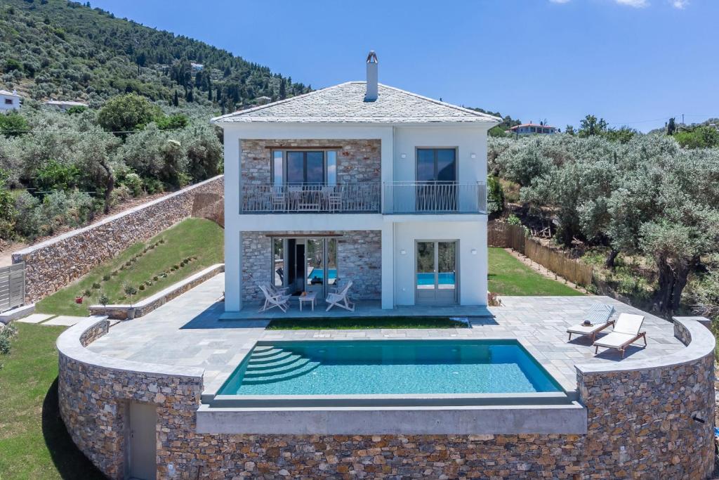 une villa avec une piscine et une maison dans l'établissement Villa Kingstone, à Skopelos