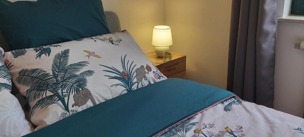 een slaapkamer met een bed met een kussen en een lamp bij LLN lodge in Louvain-la-Neuve
