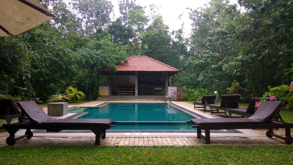 a swimming pool with two chairs and a gazebo at Refresh Cabana Gardens in Kataragama