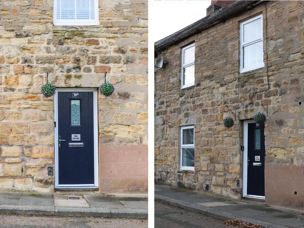 a building with a black door and a brick building at Mill Cottage in Belford