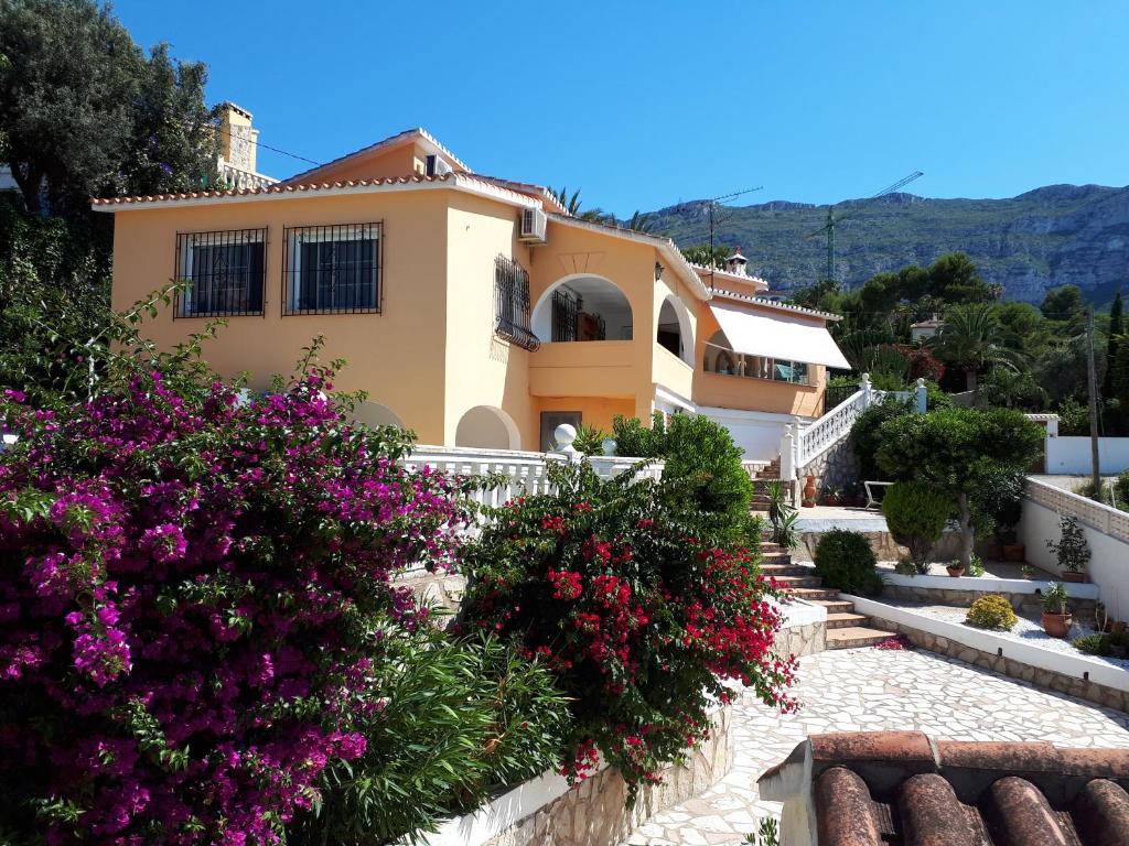 a house on a hill with flowers in front of it at Villa Denia in Denia