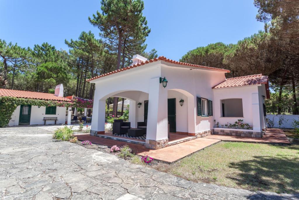 a small white house with a patio at Ocean, Pines and Mountain in Sintra