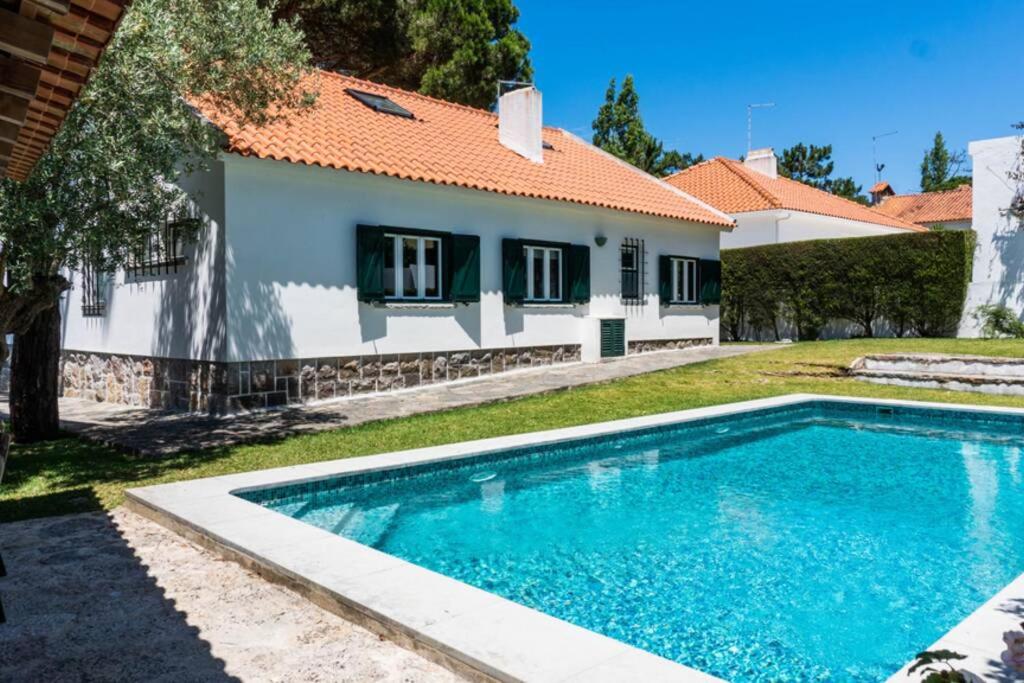 a swimming pool in front of a house at Sintra • Banzão House with Swimming Pool in Nafarros
