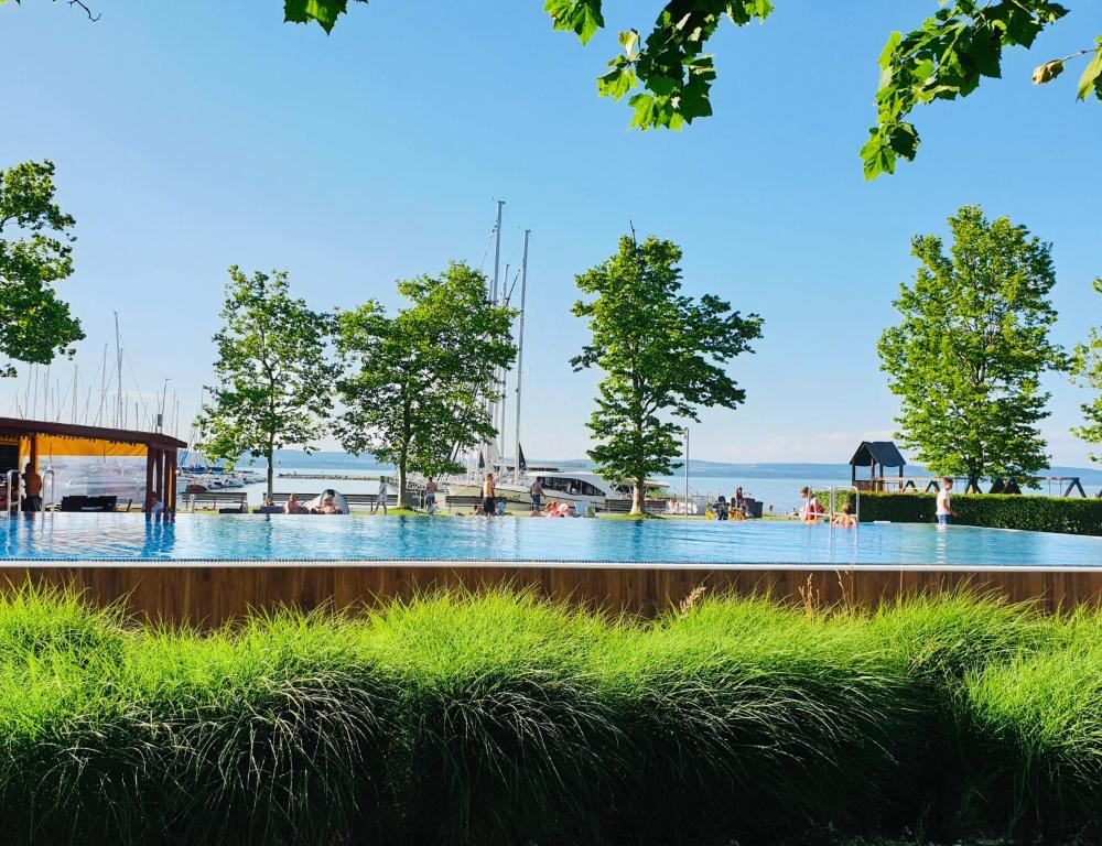 a large swimming pool with people in the water at Butique Apartman in Balatonlelle