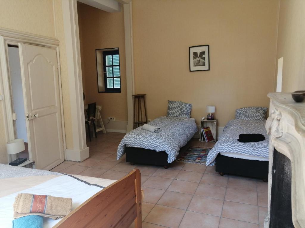 een slaapkamer met 2 bedden in een kamer bij La tour du Roy in Villeneuve-sur-Allier