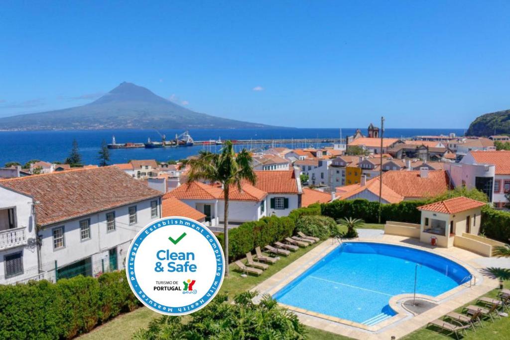 a villa with a swimming pool and a sign that says clean and safe at Hotel Horta in Horta