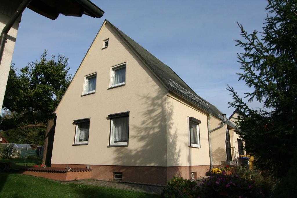 una gran casa blanca con techo de gambrel en Ferienhaus Auerswalde, en Lichtenau