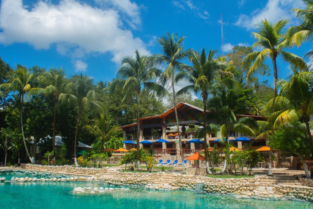a beach with palm trees and palm trees at Chan-Kah Resort Village Convention Center & Maya Spa in Palenque