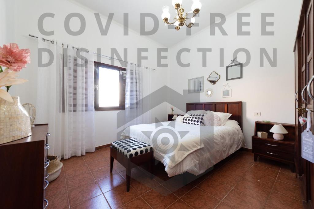 a bedroom with a bed and a chandelier at Balcony Spacious 2BR Historic Centre Arucas in Arucas