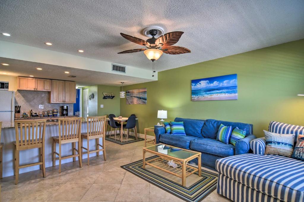sala de estar con sofá azul y cocina en Sunny Seaside Condo with Pool and Walk to Beach!, en St Pete Beach