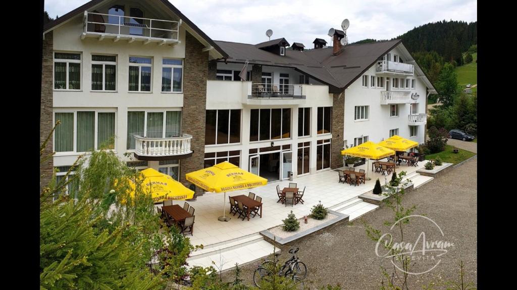 una vista aérea de un edificio con mesas y sombrillas amarillas en Casa Avram, en Suceviţa