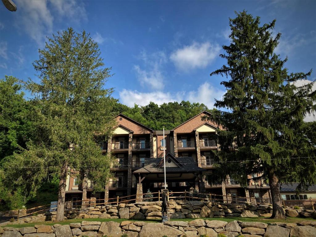 a large building with trees in front of it at Stonebrook Lodge Bryson City in Bryson City