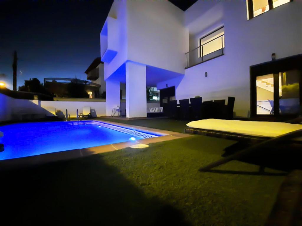 韋托爾韋加的住宿－VILLA TAZA DE PLATA A，夜间在房子前面的游泳池