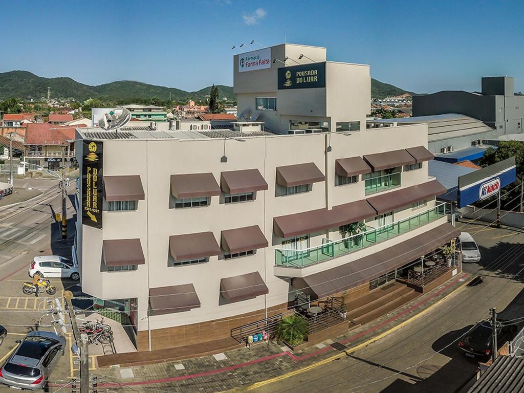 a large white building with a sign on top of it at Pousada Doluar in Penha