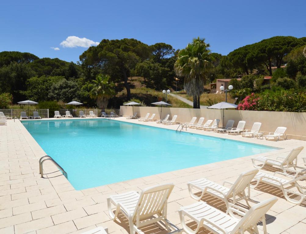 a large swimming pool with chairs and umbrellas at Le Domaine de VILLEPEY By SdR in Fréjus