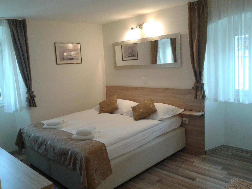 斯普利特B&B Central Palace Heritage的卧室里有一张床，床单和枕头都是白色的