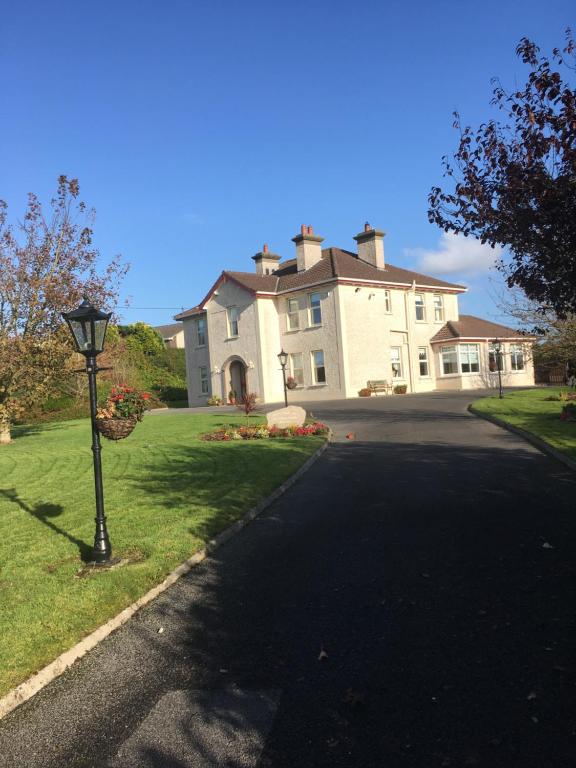 een groot huis met een straat ervoor bij Quignalegan House in Ballina