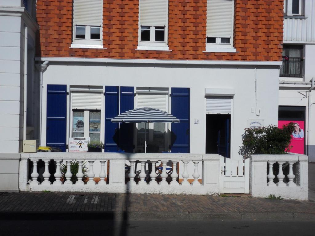 a blue and white building with an umbrella at L Imperatrice in Berck-sur-Mer