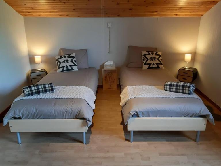 1 dormitorio con 2 camas y 2 luces en la pared en B&B Circuitez-vous, en Stavelot