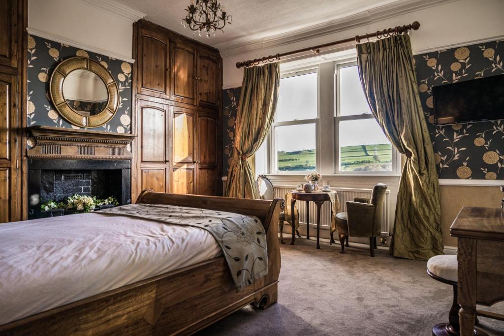 een slaapkamer met een bed, een open haard en een raam bij Shibden Hall View in Halifax