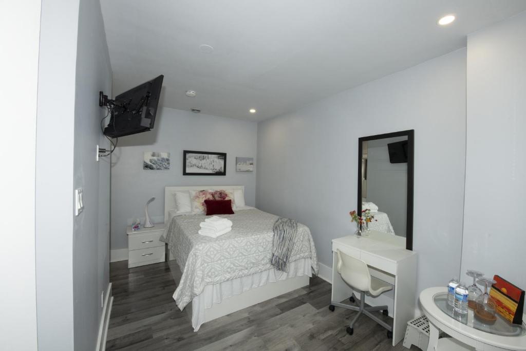 a bedroom with a bed and a desk and a mirror at Serene Niagara Inn in Niagara Falls