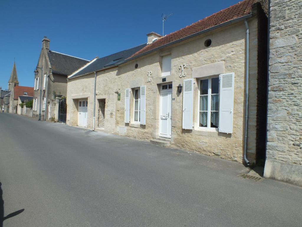 an empty street next to an old brick building at Gîte de charme Floréales Les Iris in Asnelles