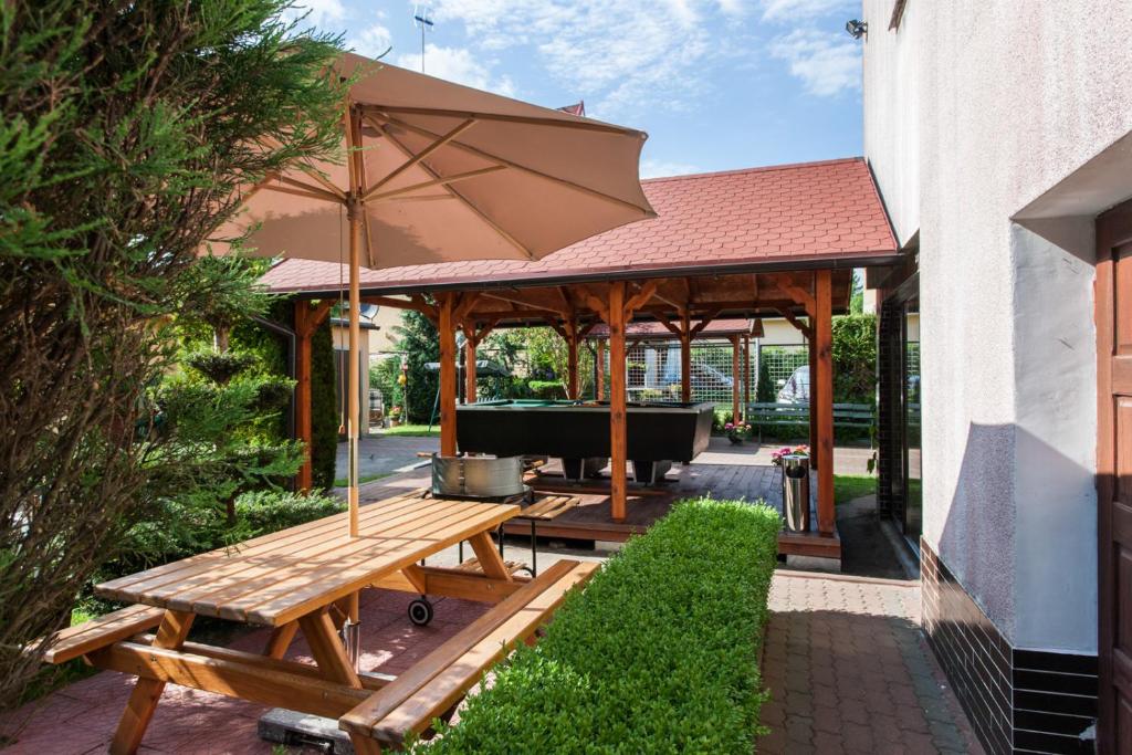 a pavilion with a picnic table and an umbrella at Wypoczynek Roda in Pobierowo