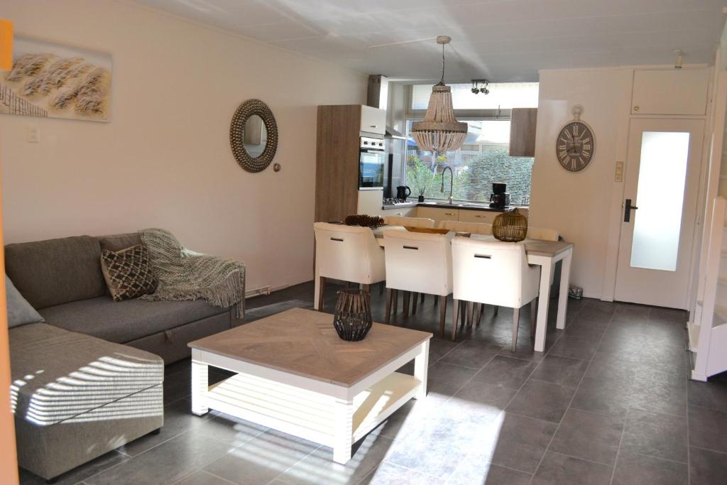 uma sala de estar com um sofá e uma mesa em Beachy Chic Zandvoort em Zandvoort