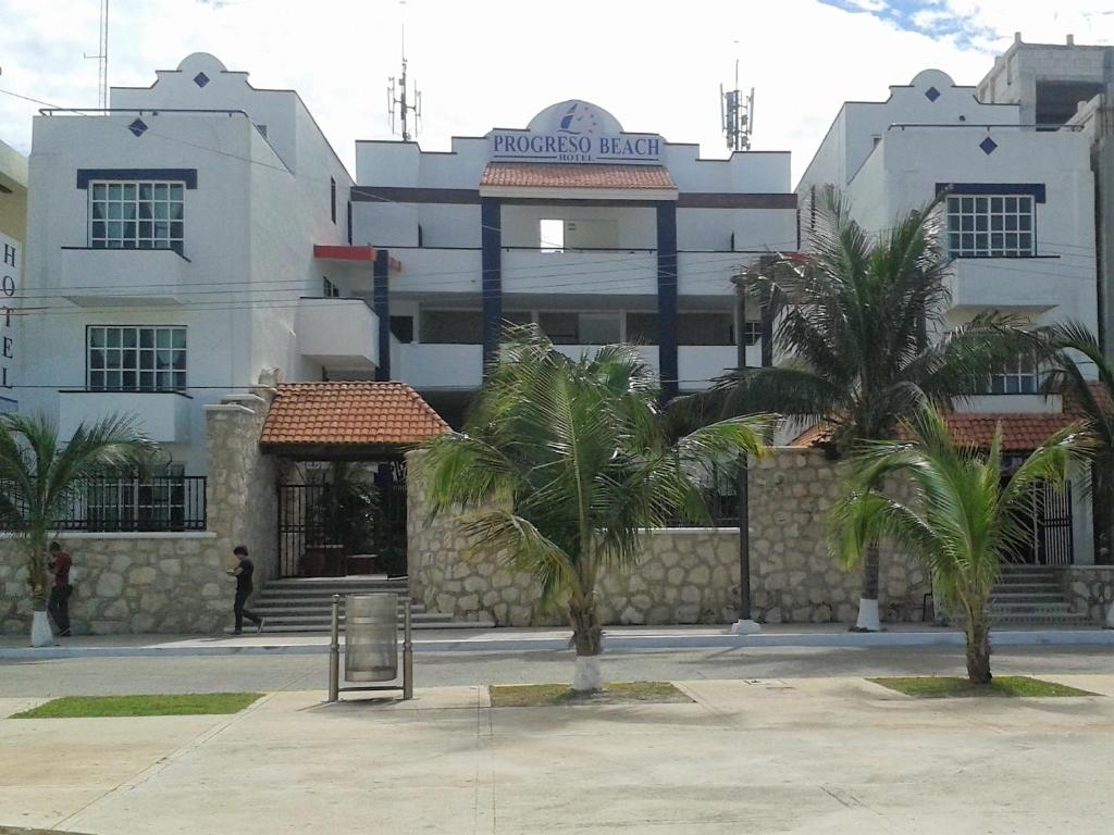 un edificio con palmeras delante en Progreso Beach Hotel, en Progreso