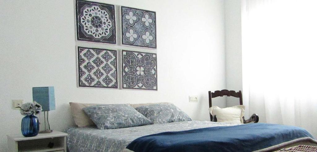 1 dormitorio con 1 cama con edredón azul en La Casa de Maribel, en Priego de Córdoba