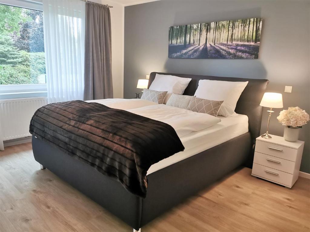 a bedroom with a large bed and a large window at Heykens Golfhuus Albatros in Wiesmoor