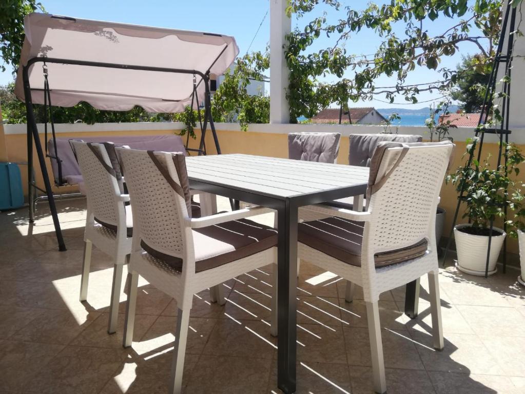 una mesa blanca y sillas en un patio en Warm Terrace Apartments, en Zadar