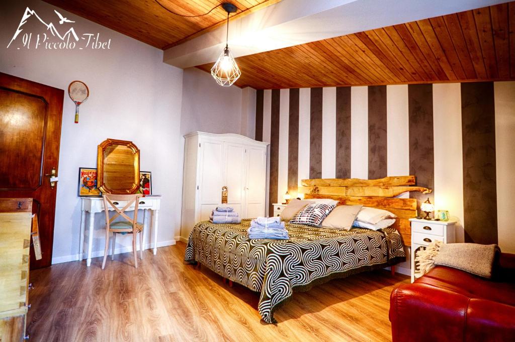 ein Schlafzimmer mit einem Bett und einer gestreiften Wand in der Unterkunft Il Piccolo Tibet - Gran Sasso in LʼAquila