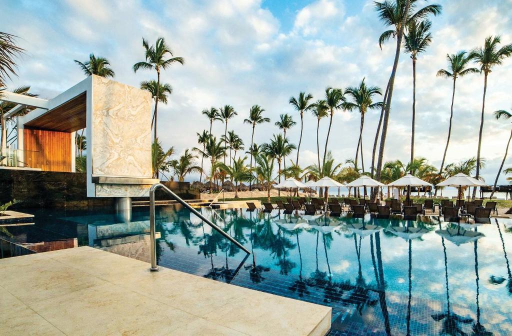 a view of the pool at a resort with palm trees at Secrets Royal Beach Punta Cana - Adults Only in Punta Cana