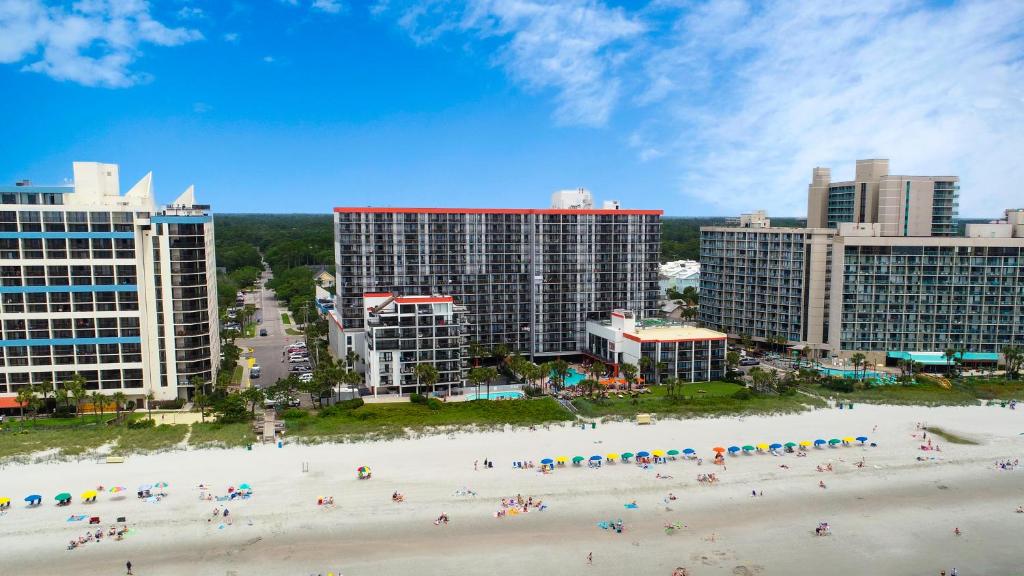 a group of people on a beach in front of buildings at Grande Cayman Resort in Myrtle Beach