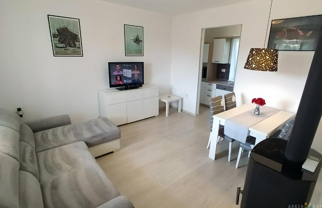 een woonkamer met een bank en een tafel bij Pure nature coastal apartment VLASTA in Ankaran