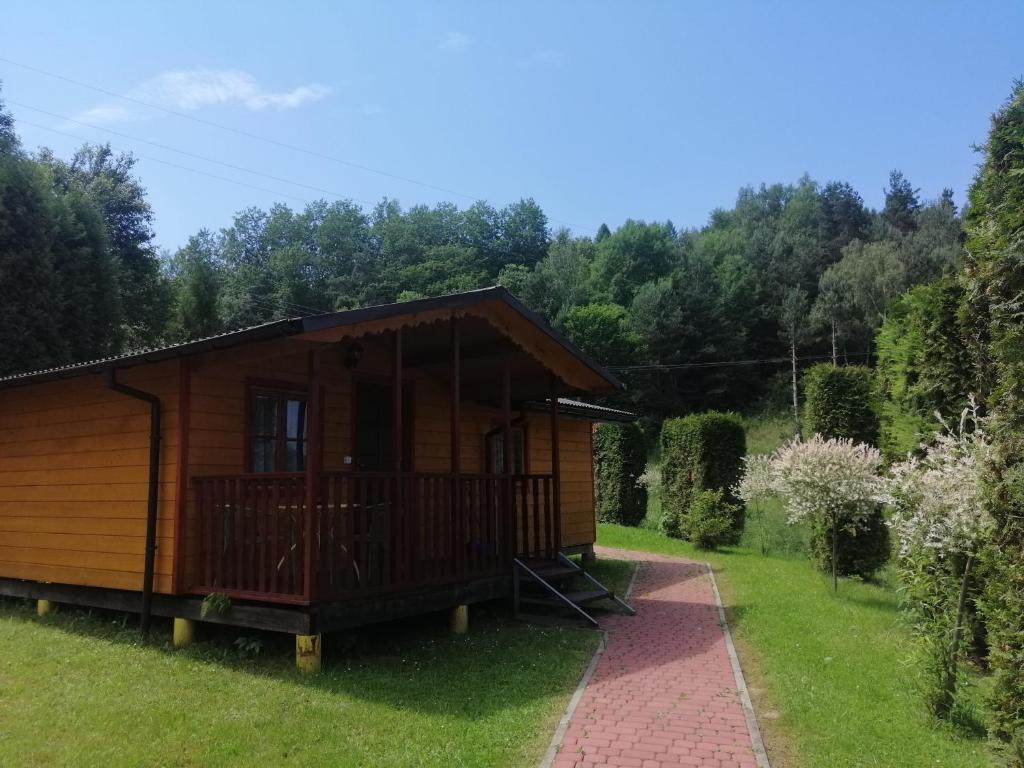 a small wooden cabin in a field with trees at Eko-Wakacje in Polańczyk