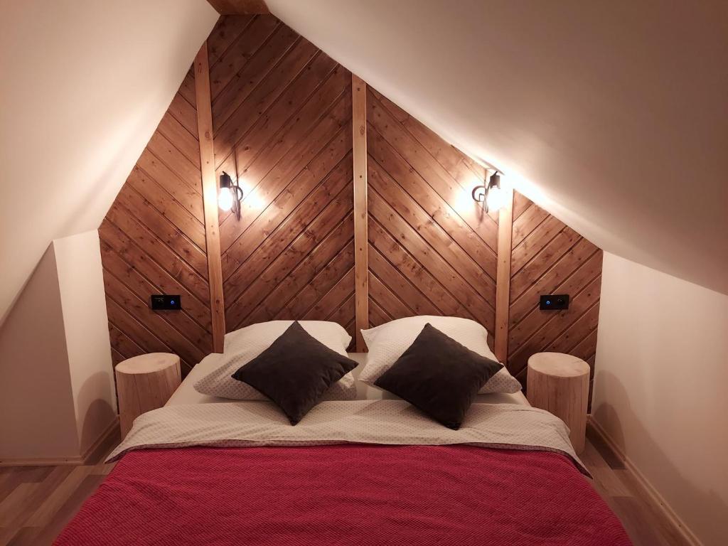 1 dormitorio con 1 cama grande y cabecero de madera en U Młynorza, en Suche