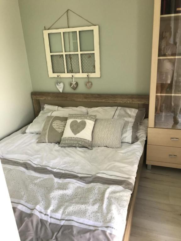 a bed with white sheets and pillows in a bedroom at Apartament W Sercu Ostródy in Ostróda