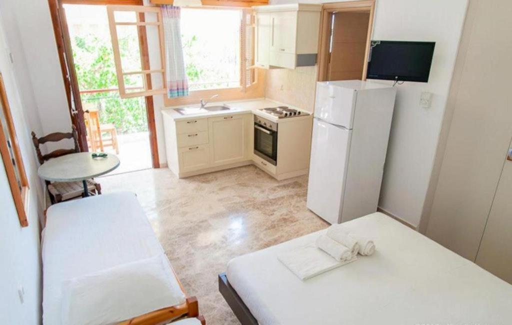 a small kitchen with a refrigerator and a table at Margarita Apartments in Kanali