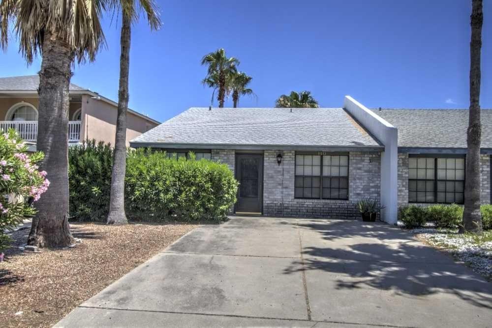 a house with palm trees and a driveway at The Campeche Town House Townhouse in South Padre Island