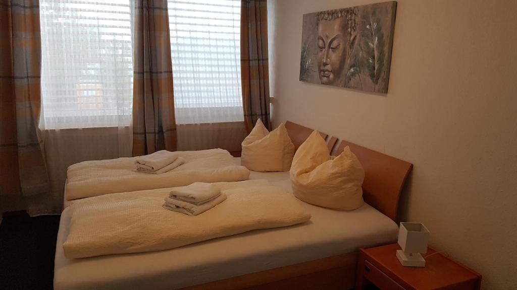 Dos camas en una habitación de hotel con toallas. en Pension RUBIN en Bremen