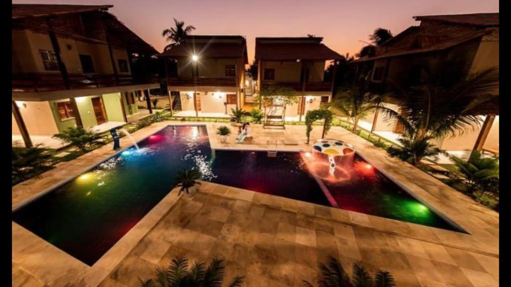 a swimming pool with lights in the middle of a house at Pousada Recanto Beach in Camocim