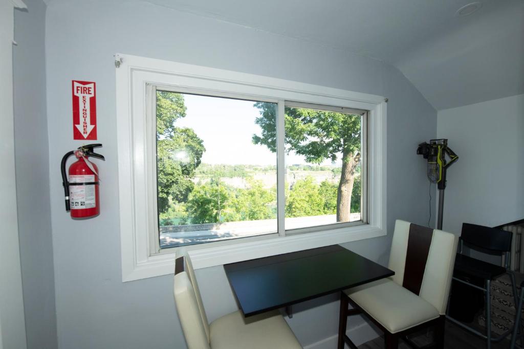 a room with a window and a table and chairs at Serene Niagara Inn in Niagara Falls