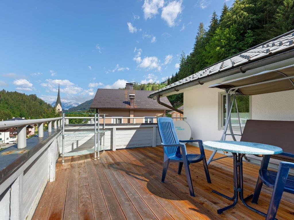 a deck with a table and chairs on a balcony at House in H ttau near Salzburg Airport in Hüttau