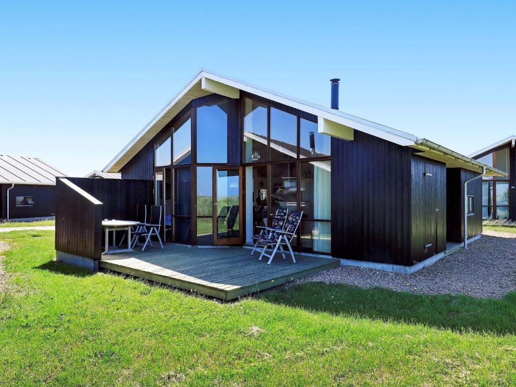 een huis met een terras met twee stoelen erop bij 8 person holiday home in Ulfborg in Thorsminde